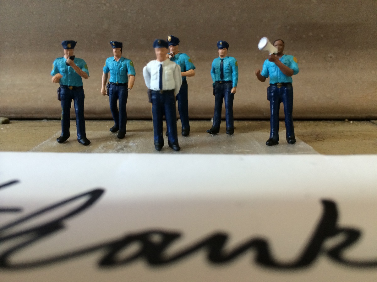 A close-up shot of the police officers lined up behind a note